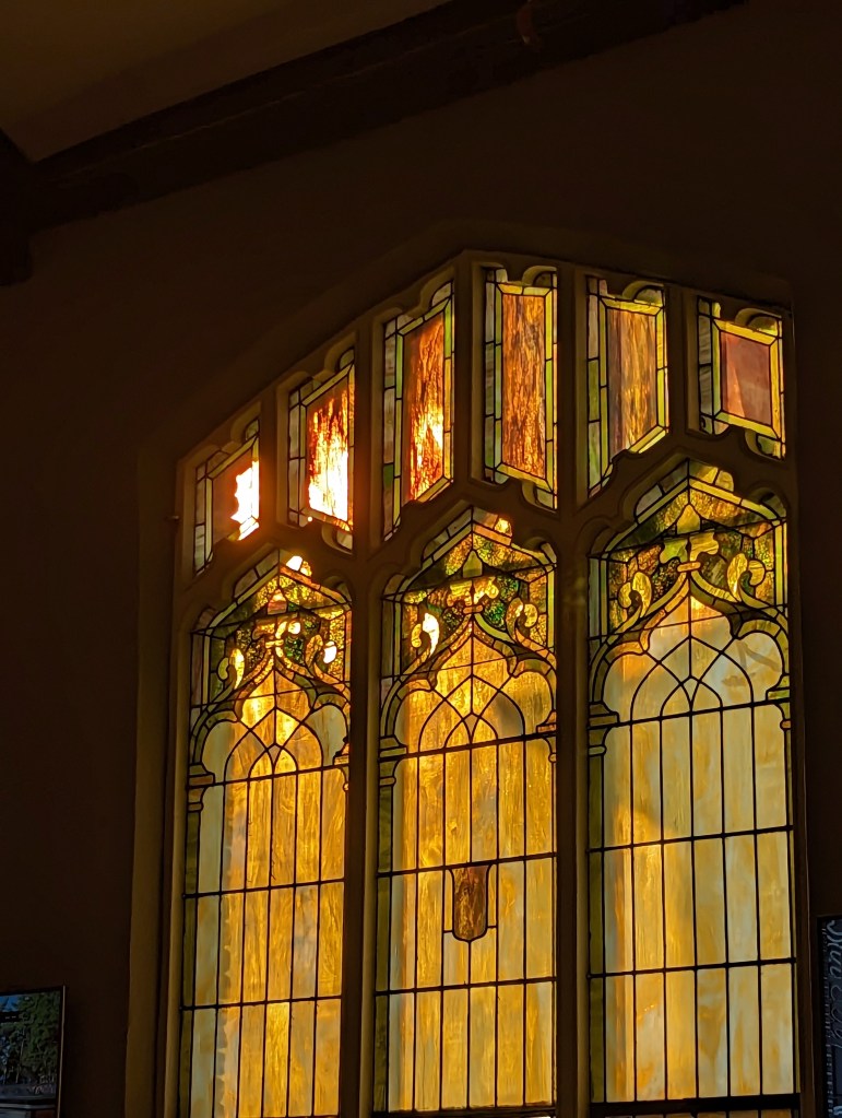 Setting sun shining through a stained glass window at Moeller Brew Barn in Troy