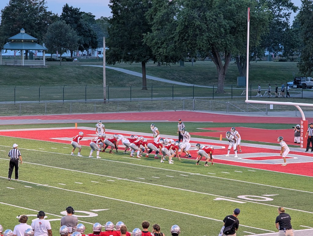High school football action with the offensive team lined up just outside the endzone